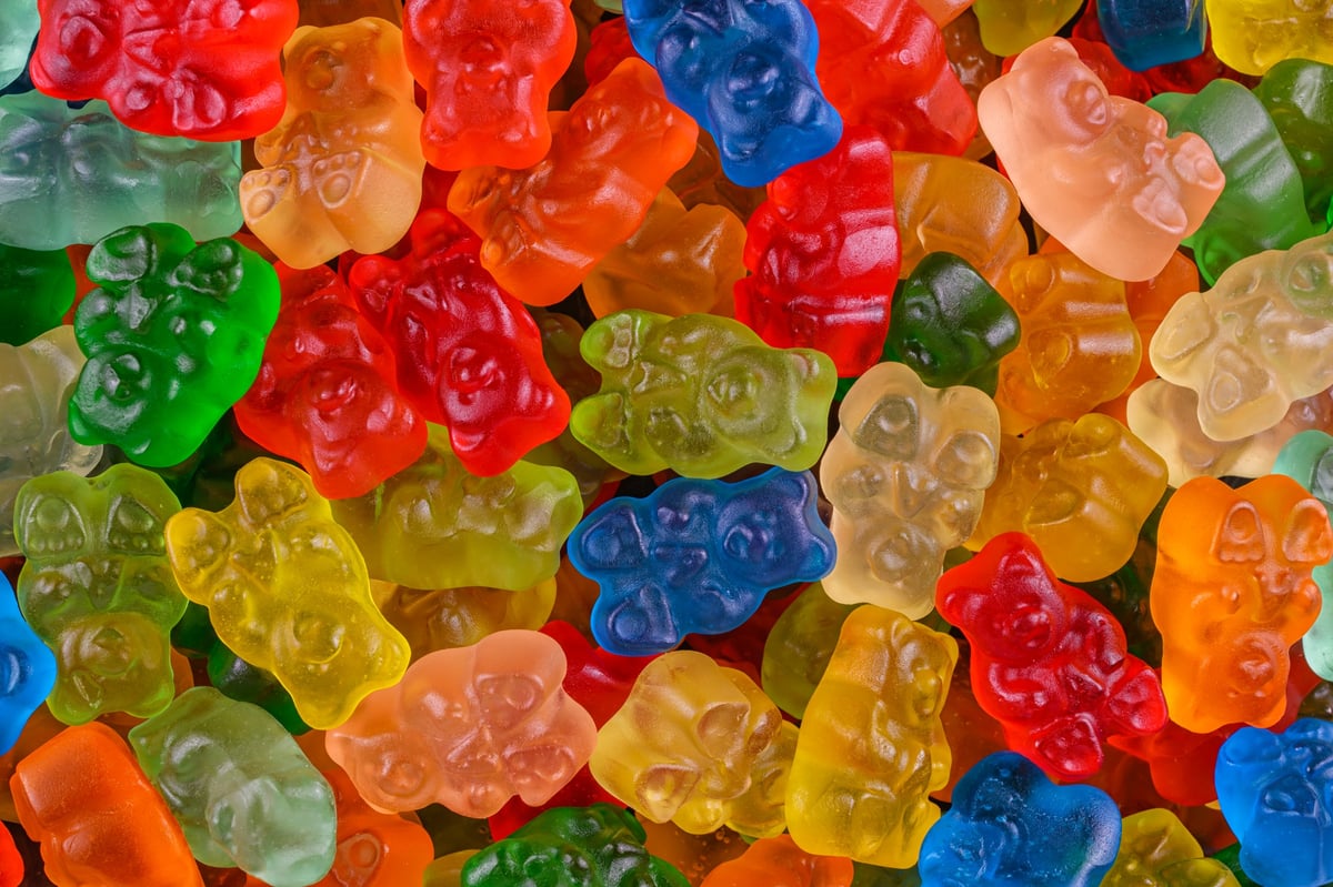 Close-up of assorted colorful gummy bears scattered randomly. Fun, vibrant and sweet candy background perfect for kids treats, dessert menus, party invitations and playful food advertising visuals.