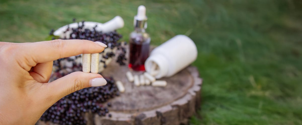 Different forms of natural elderberry medicine. Liquid extract in a bottle and capsules. Immunity.